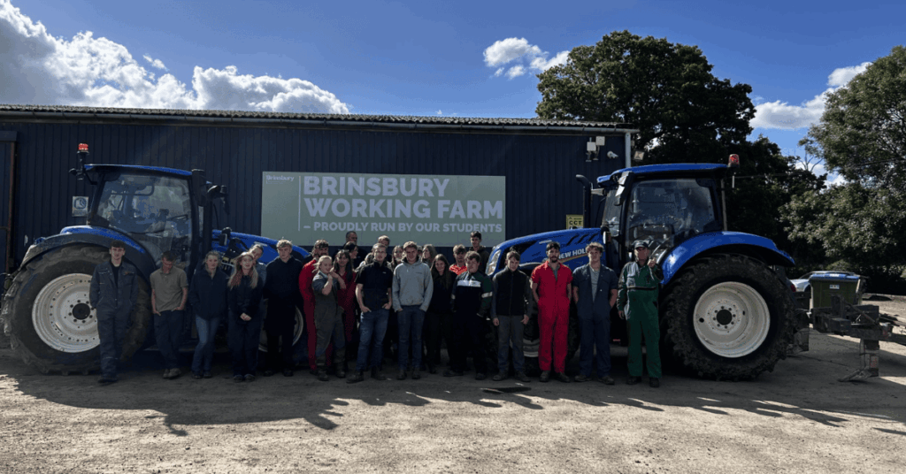 A picture of a group of our students and staff stood right behind one of the on loan tractors